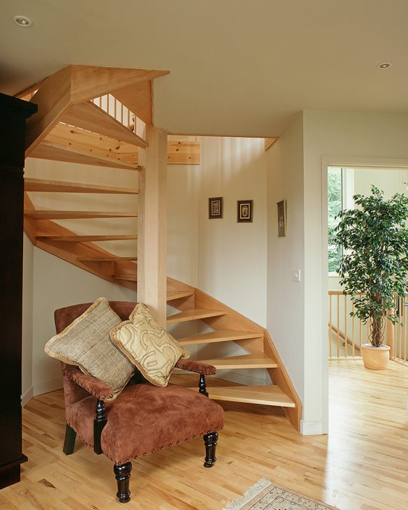 Feature spiral floating wooden staircase with pink armchair in front