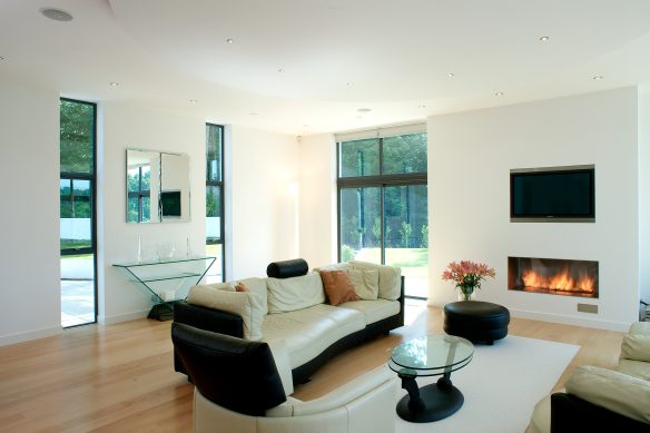 bright living room space with floor to ceiling windows and cosy built in fire place