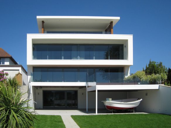 rear view of modern house with balconies and boat shed under first floor