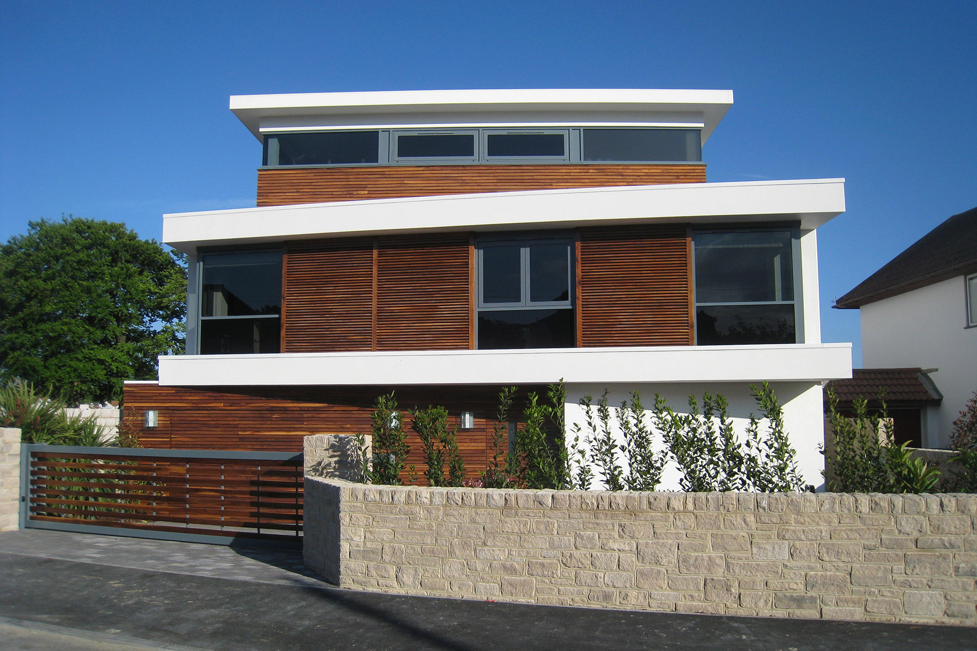 approach view of contemporary house with wood clad from street view