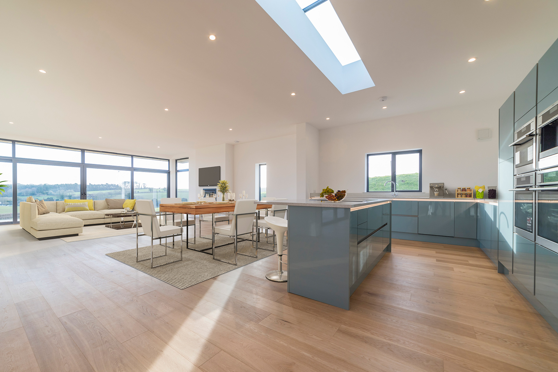 open plan kitchen and living area with skylight and large windows