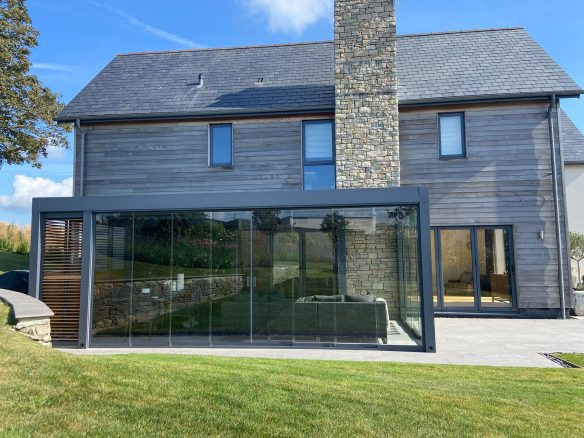 rear view of house with modern garden room extension with sliding glass doors