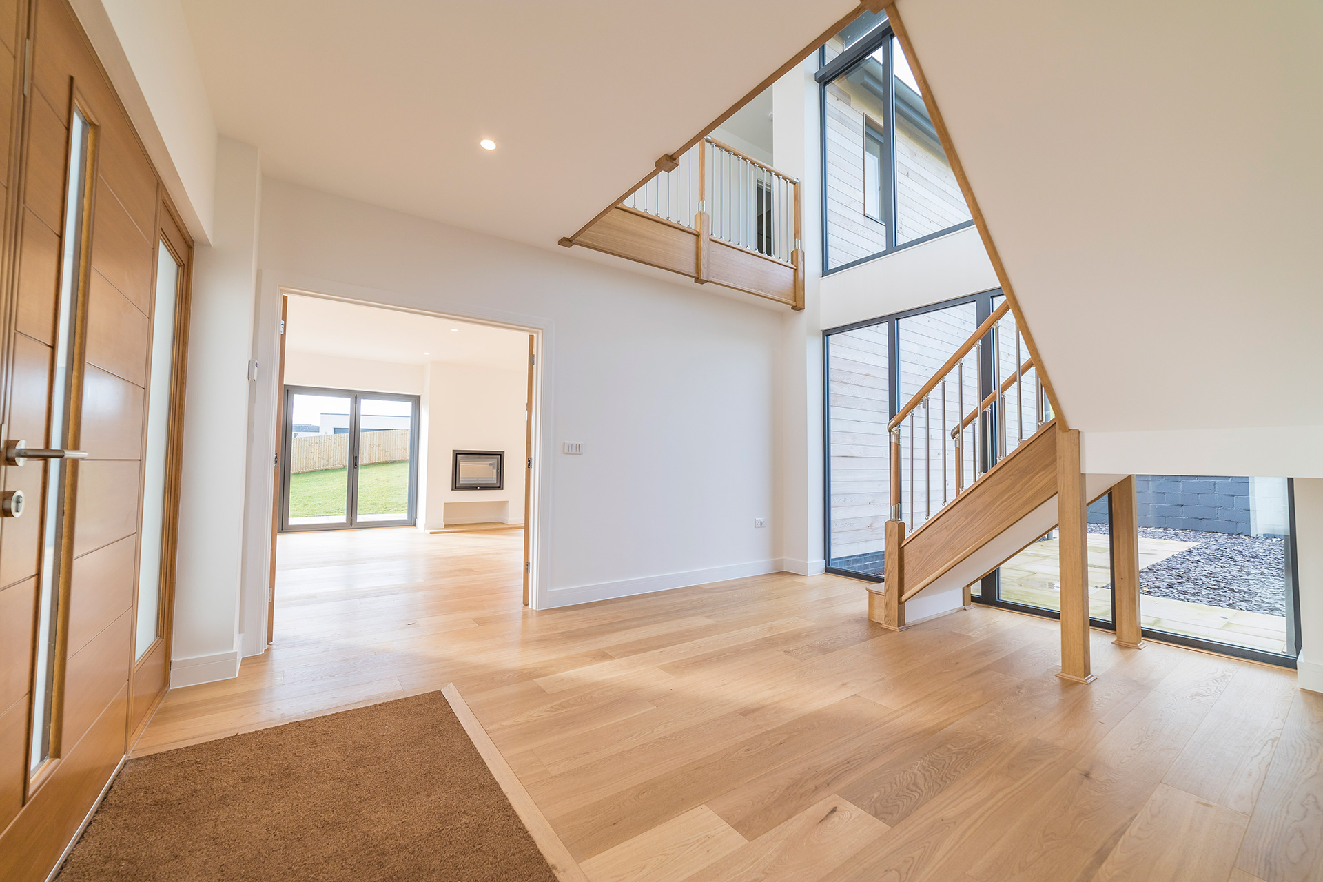 modern large hallway with dog legged wooden staircase