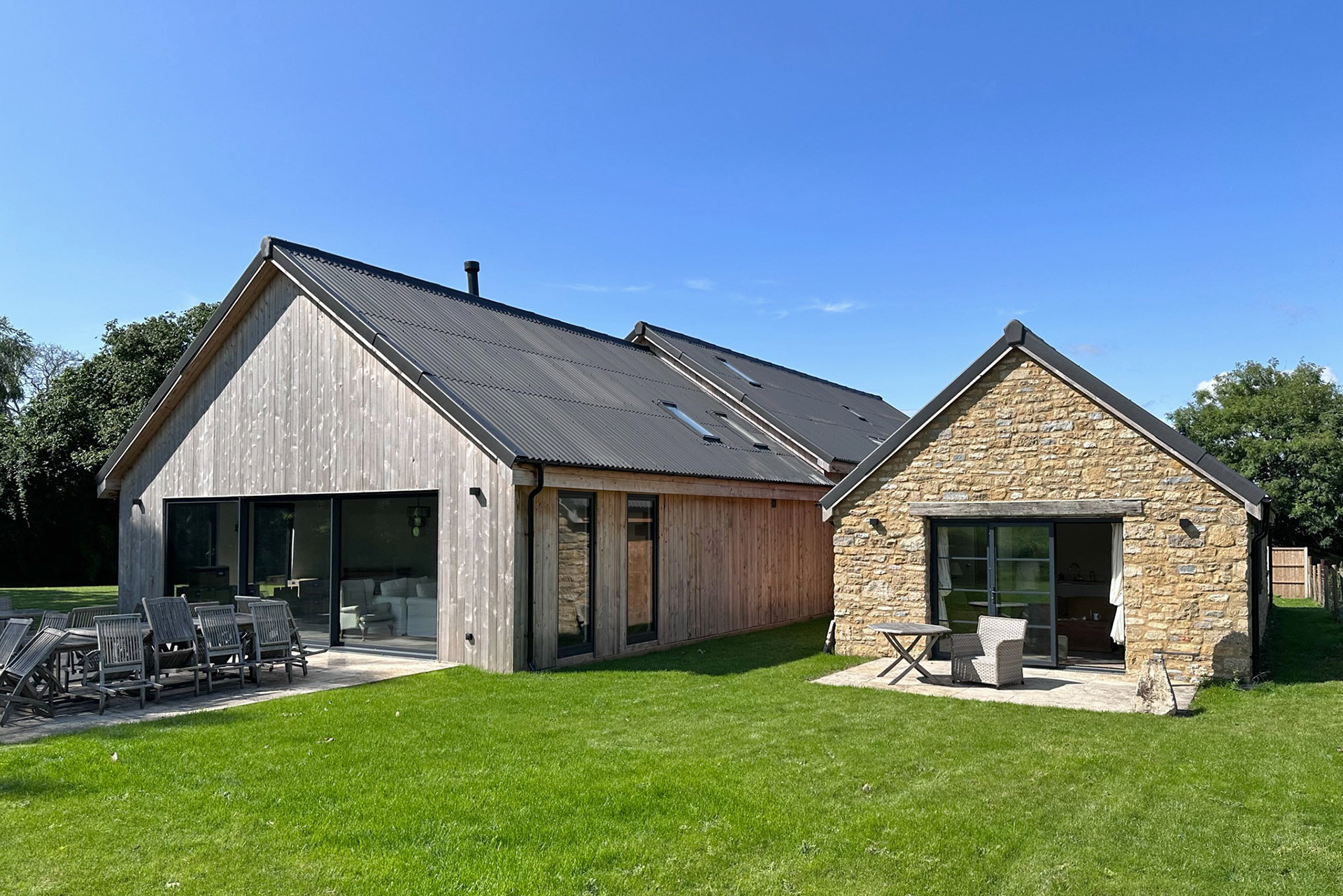 rear view of finished barn conversion with stone wall and timber cladding