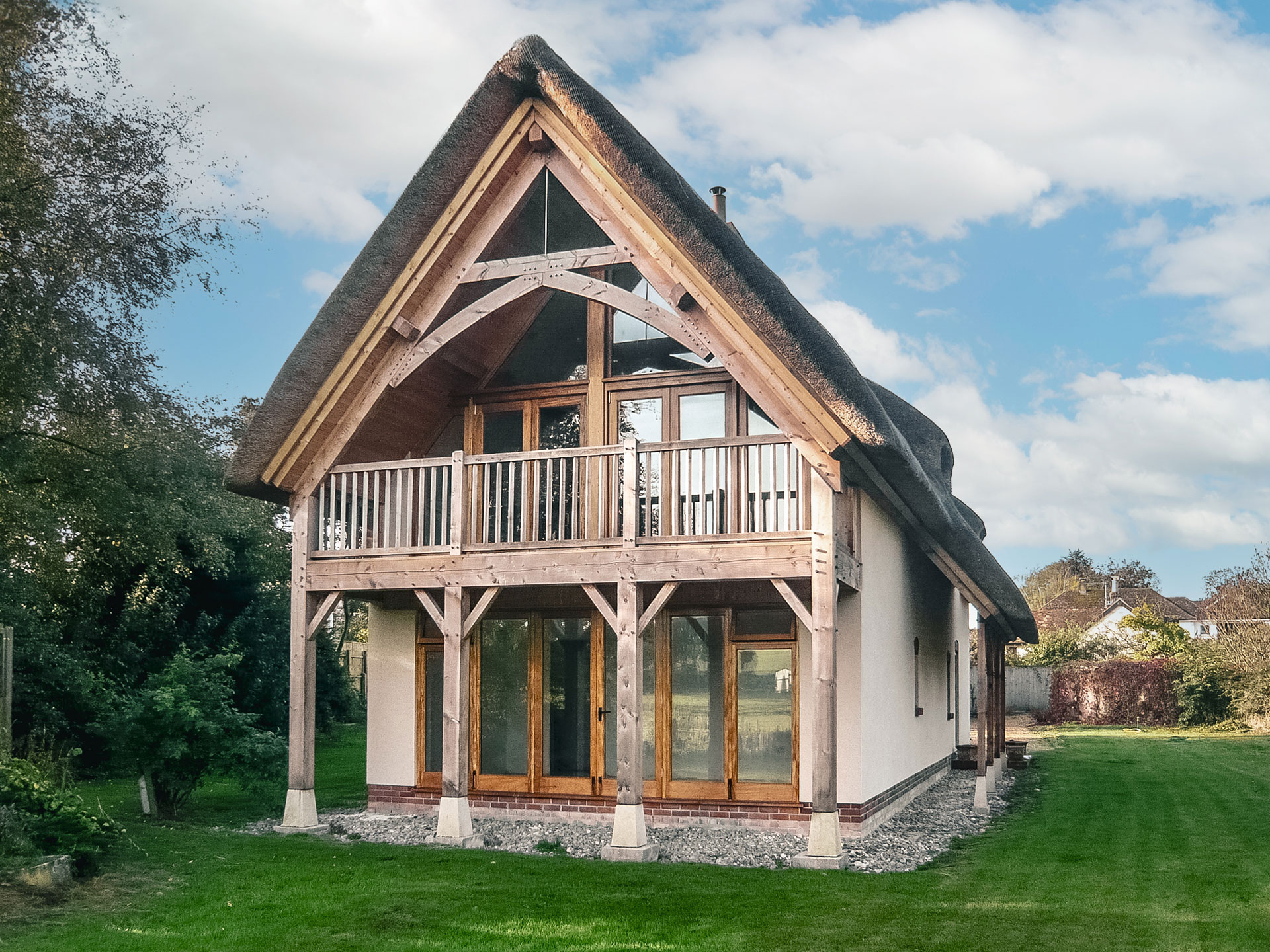 detached thatched house with glazed gable and beautiful timber balcony