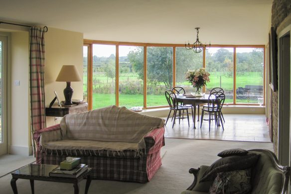 living and dining open plan area with large curved windows overlooking countryside