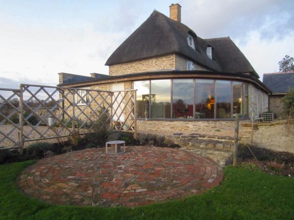 side view of extension with large windows and stone wall