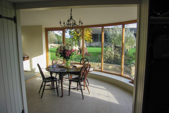 dining area with table and chairs, with large windows overlooking garden and barn