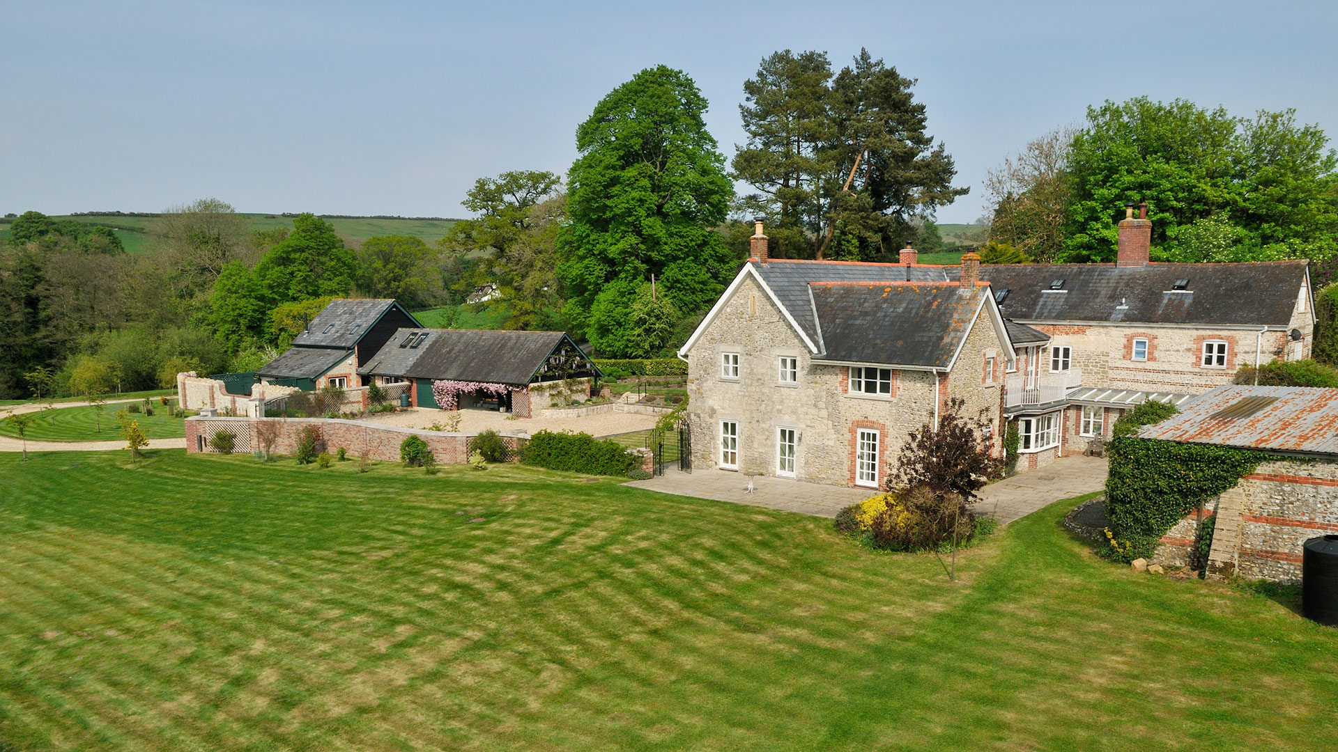 garden view of heritage stone with outbuildings and parking area