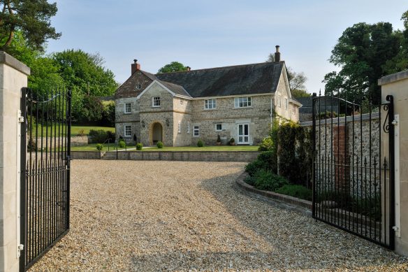 approach view of large heritage house with gravel driveway