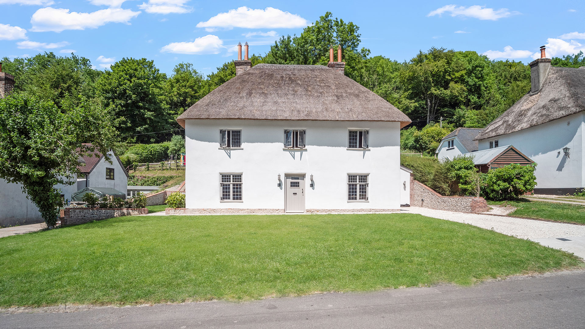 front view of white house with thatched roof