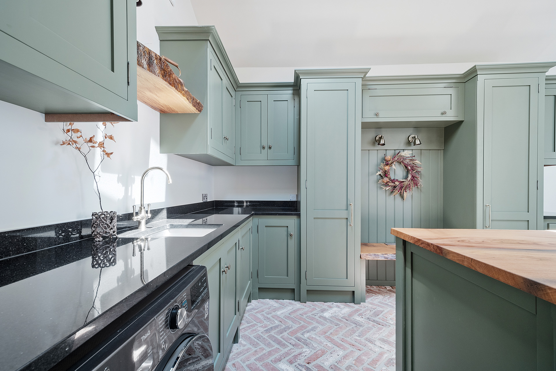 utility room with green cupboards and black countertop