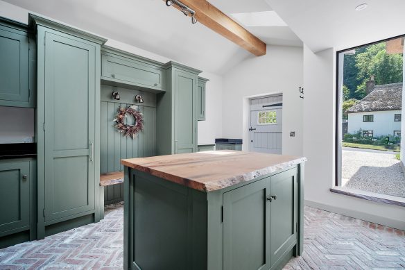 modern boot room area in white and green with stable door and large window