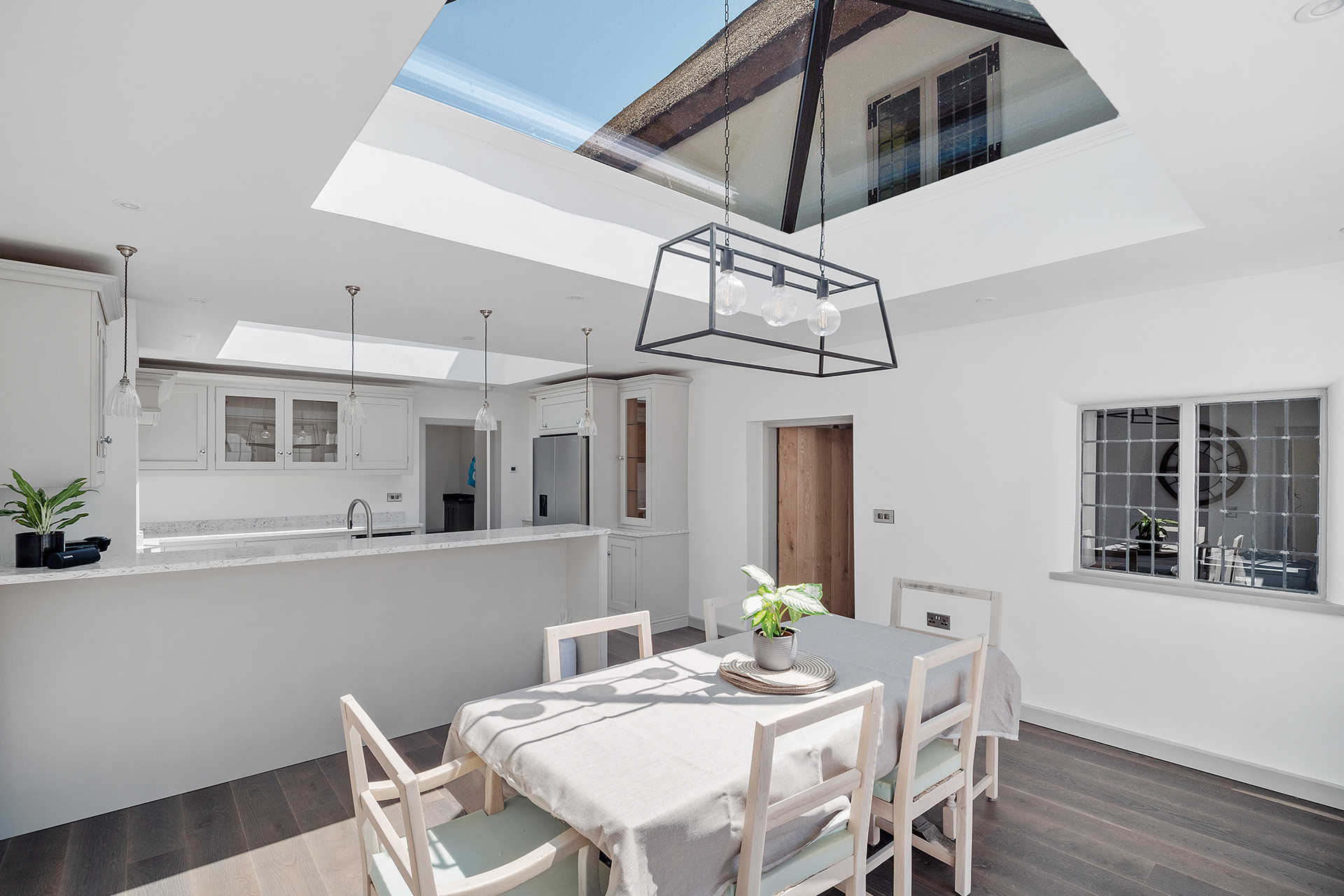 modern large kitchen extension area in white tones with large roof window