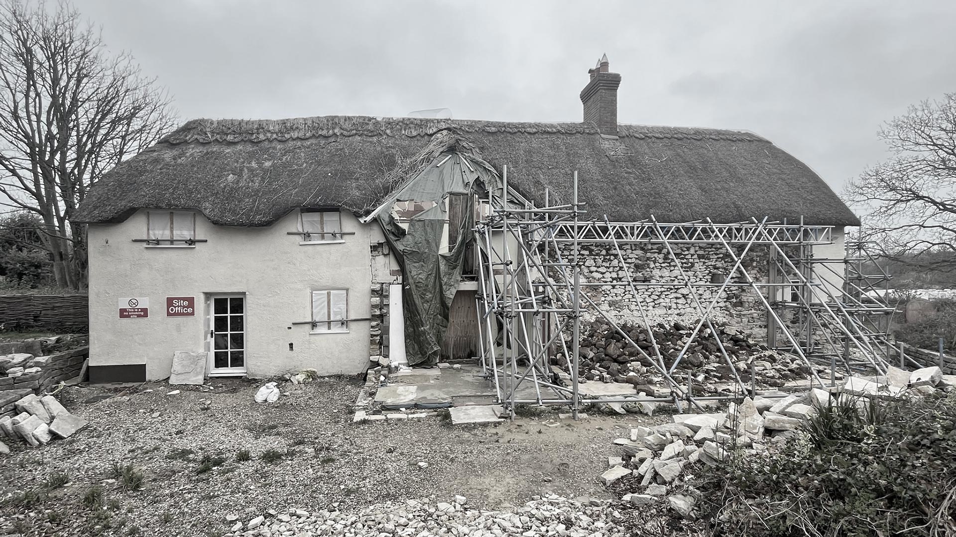 before photo of thatched cottage with scaffolding