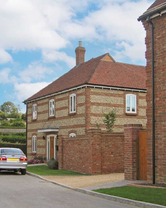 approach view of house with stone and flint walls