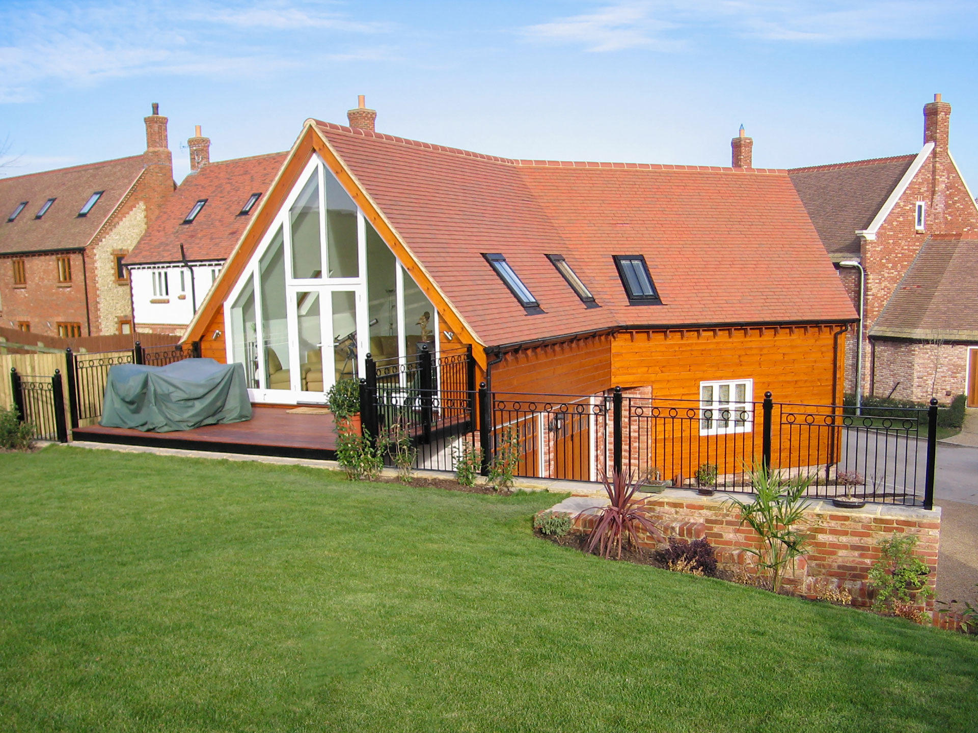 timber framed house with balcony on first floor leading to garden