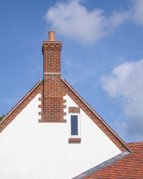 detail photo of brick chimney on white house