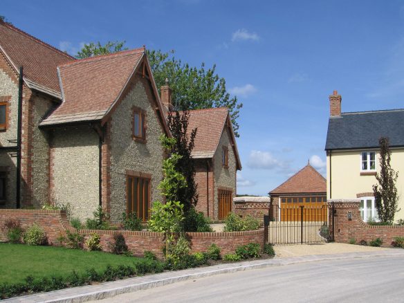 approach road view of flint house with gates in front of driveway