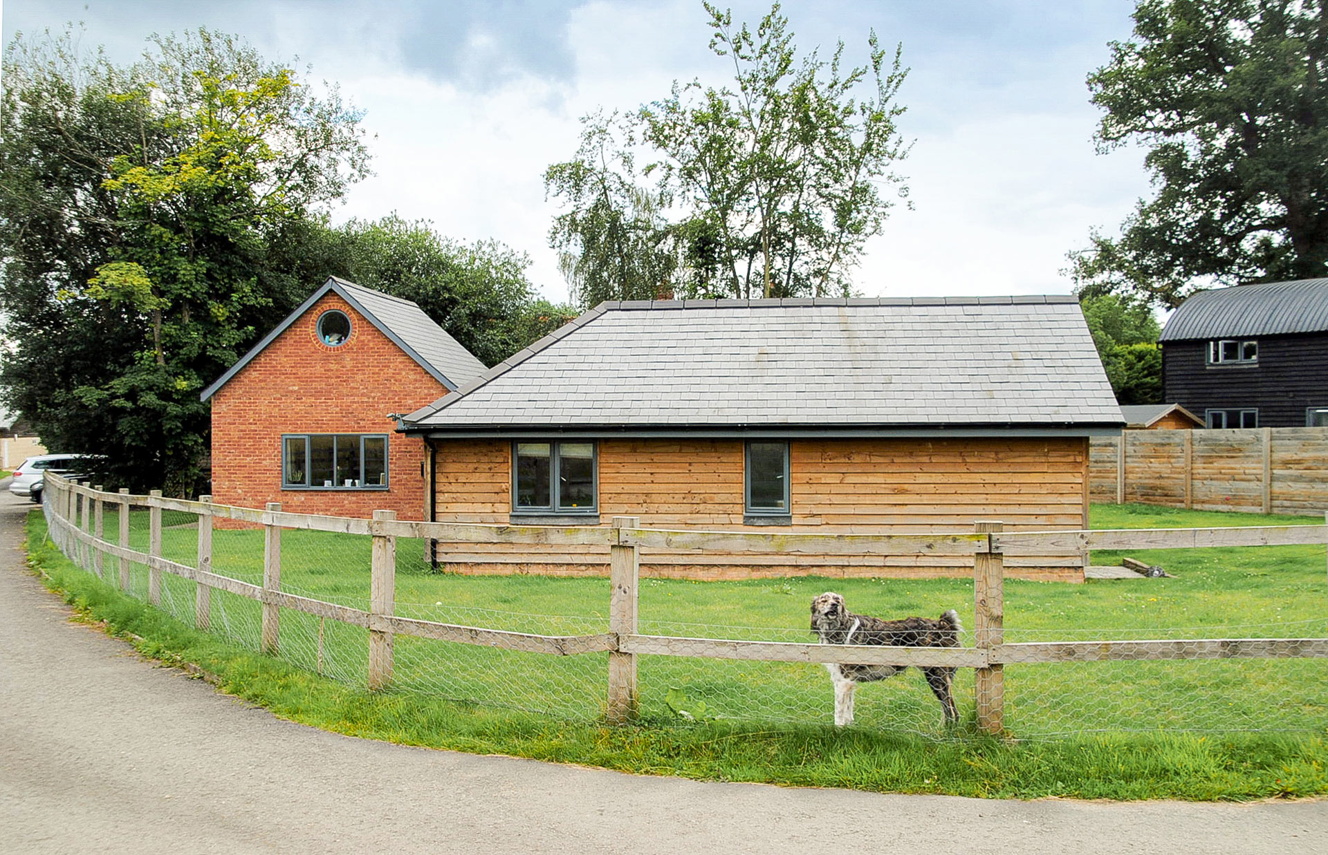 Class Q barn conversion surrounded by fenced garden with dog