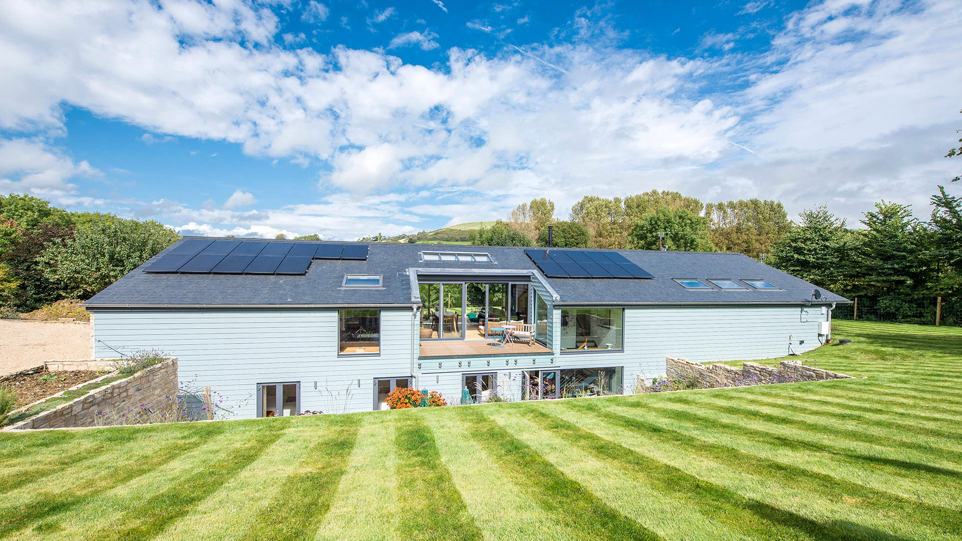 Rear view of modern house with solar panels and blue cladding