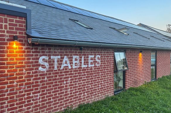 Barn conversion to community building with red brick walls and solar panels on roof