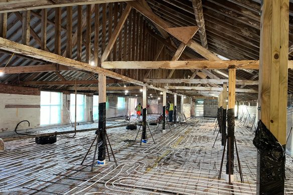 Underfloor heating being laid down in barn conversion with exposed beams