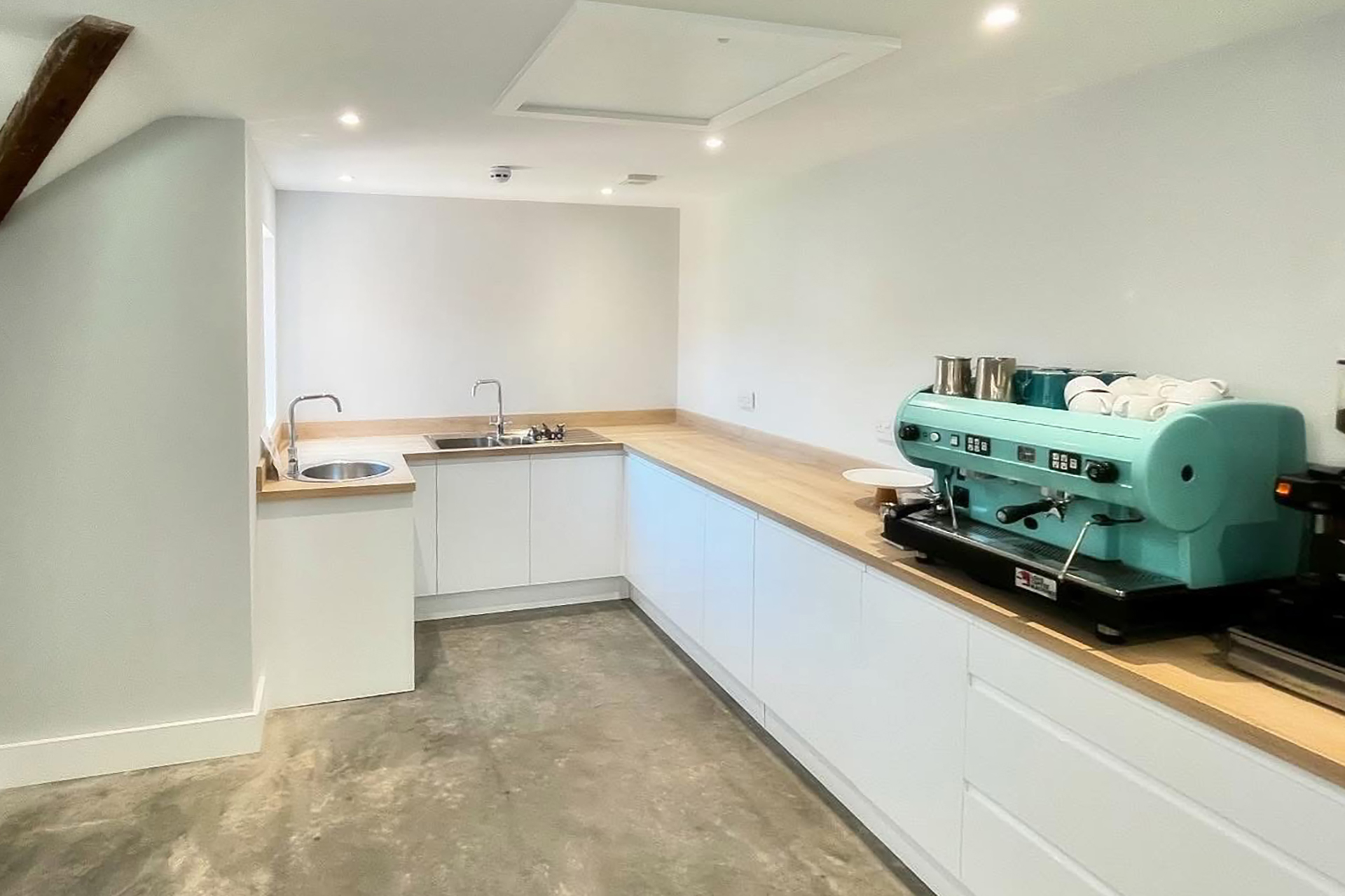 Kitchen area with large coffee machine and two sinks