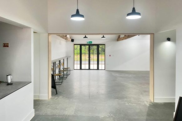 Social area in community centre with concrete floor and exposed timber beams