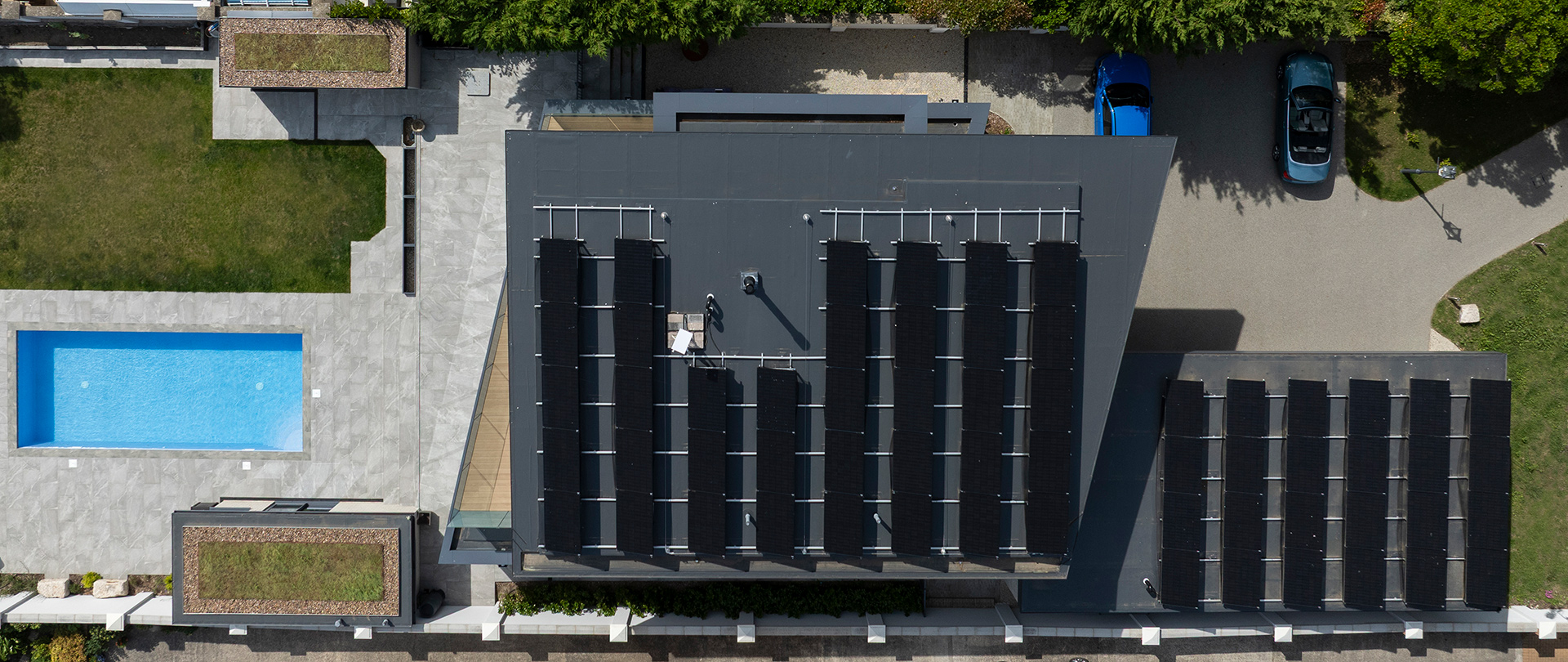 Aerial view of roof of house with solar panels and swimming pool
