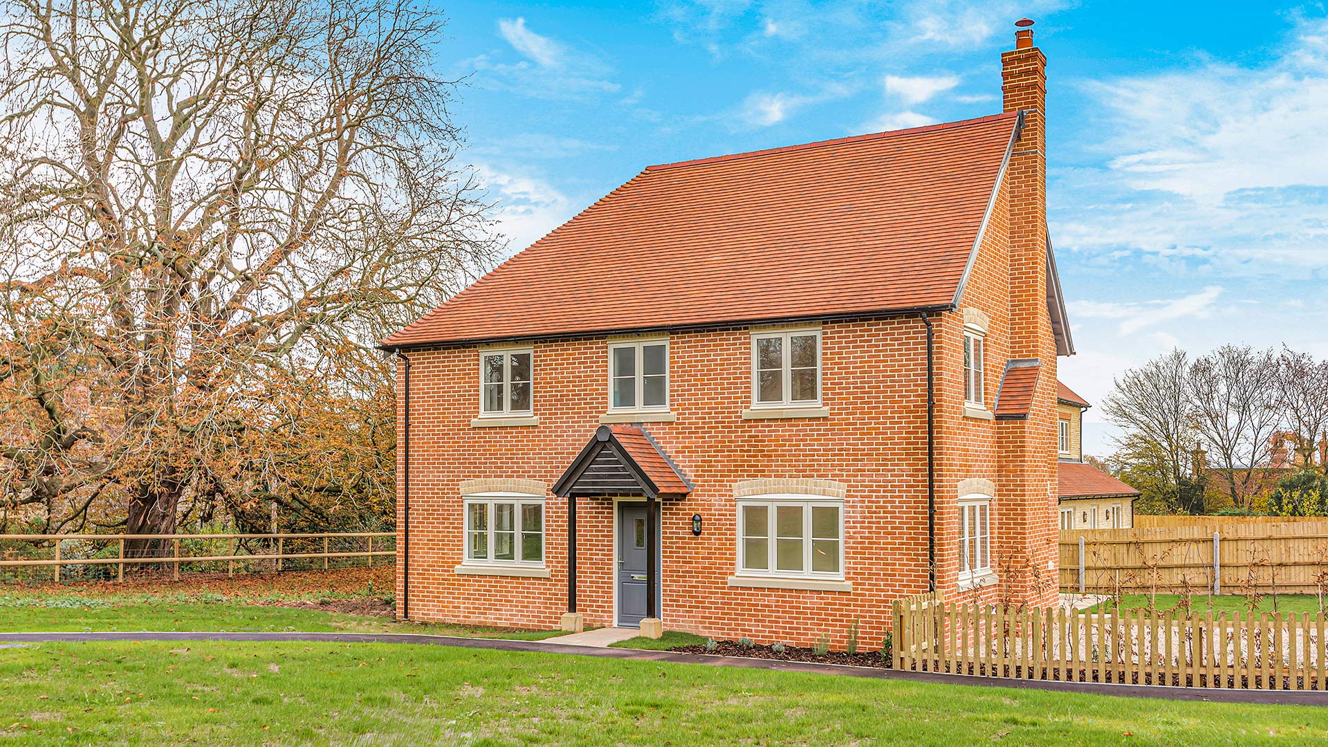 Detached red brick house with garden to side