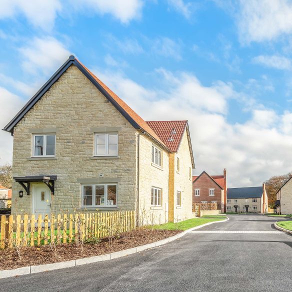 Entrance to new housing with stone walls and red tiles roof