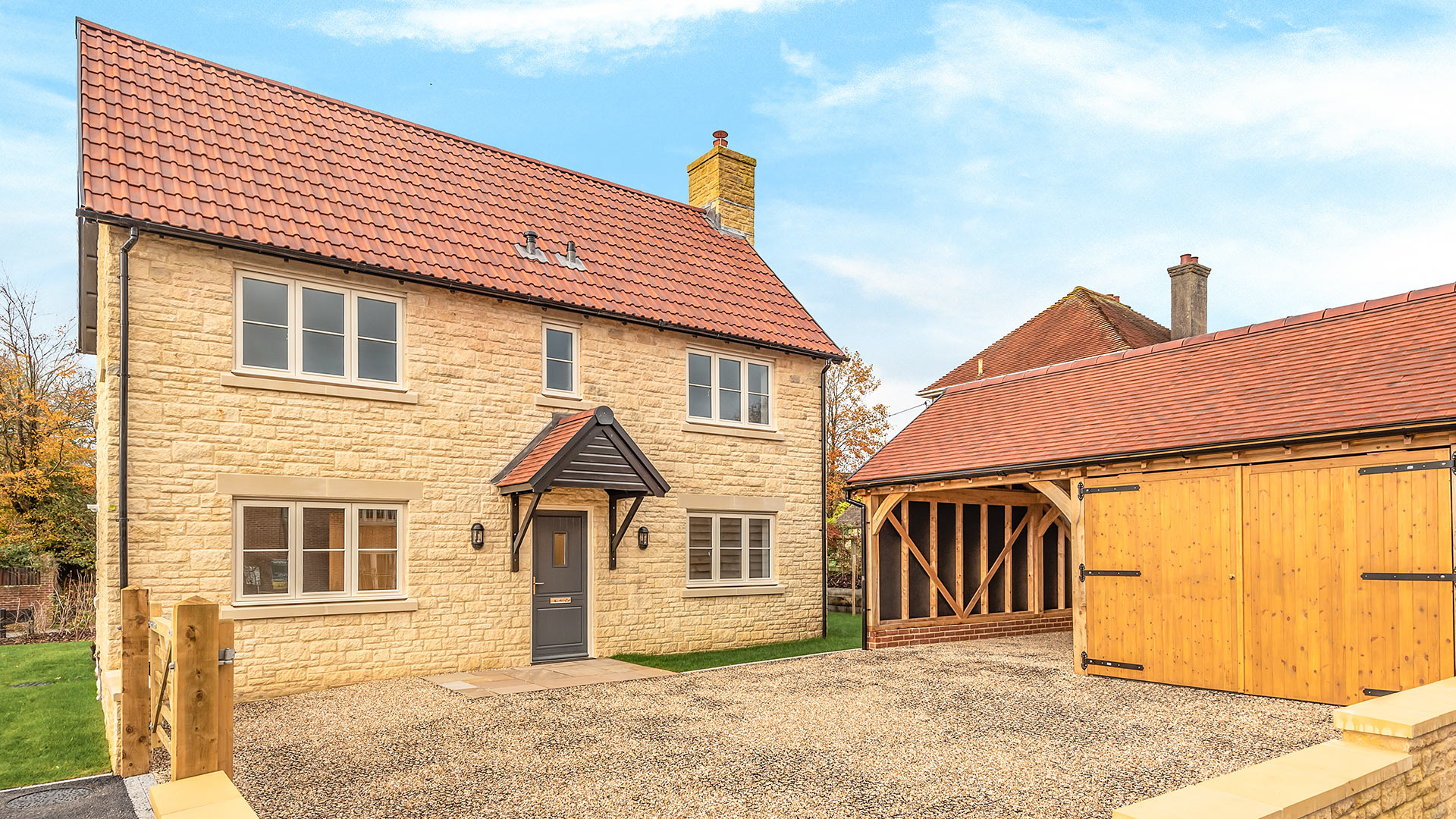 Detached stone house with detached garage and parking area