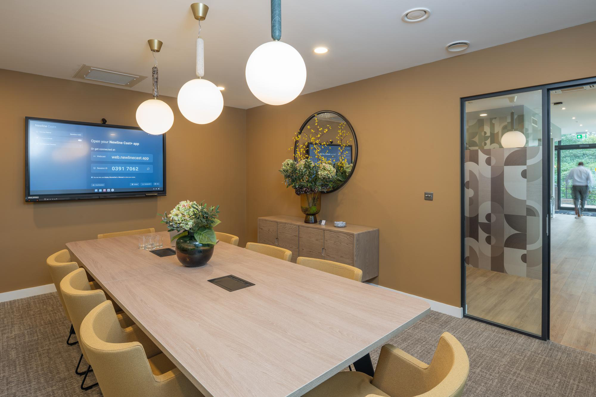 contemporary meeting room area in yellow tones with large desk and seating