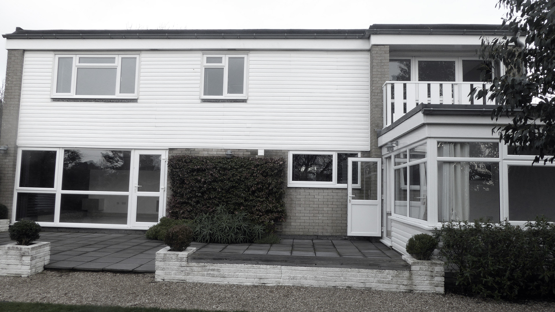 before photo of rear of house with flat roof and patio area in garden