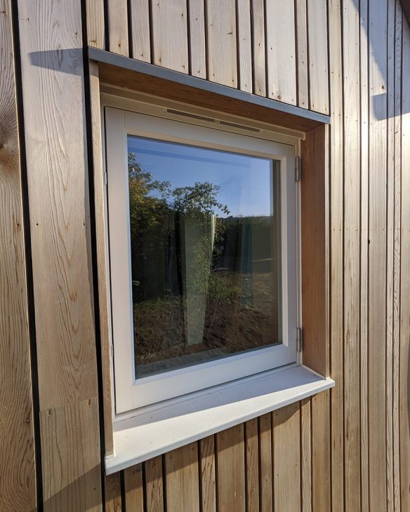 Detail photo of window with timber cladding wall