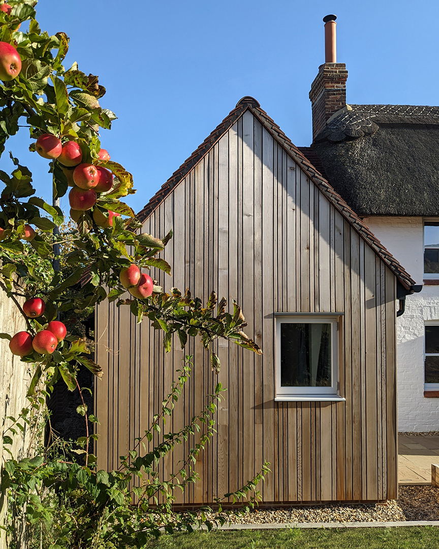 Timber cladding extension to traditional thatched house