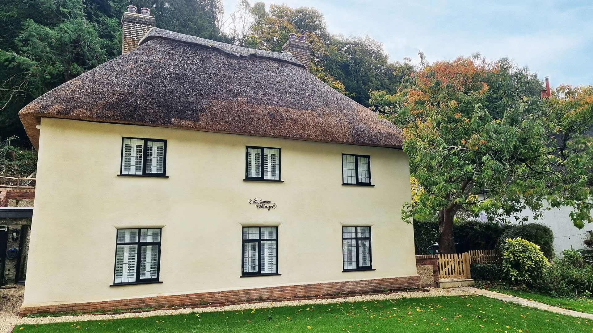 Residential exterior front view of detached thatched cottage