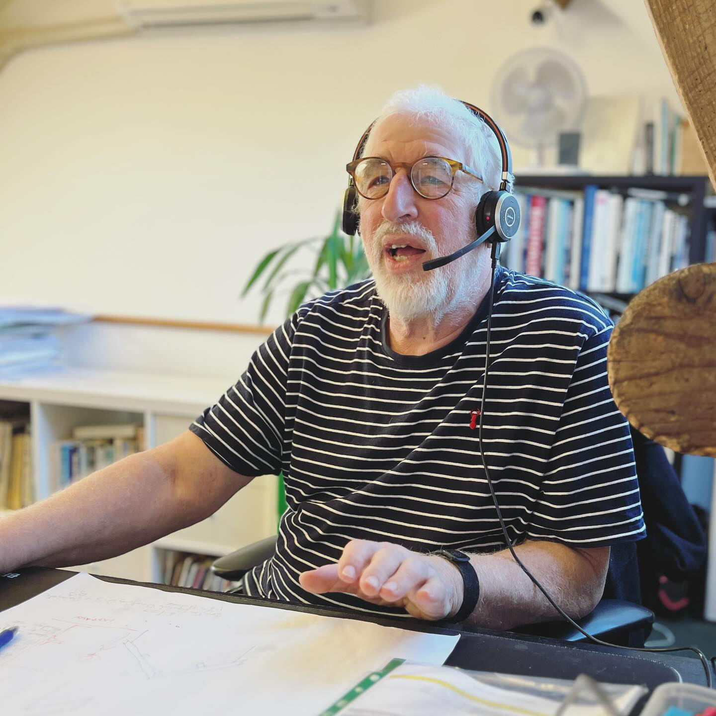 Director sitting at computer giving a presentation with headphones