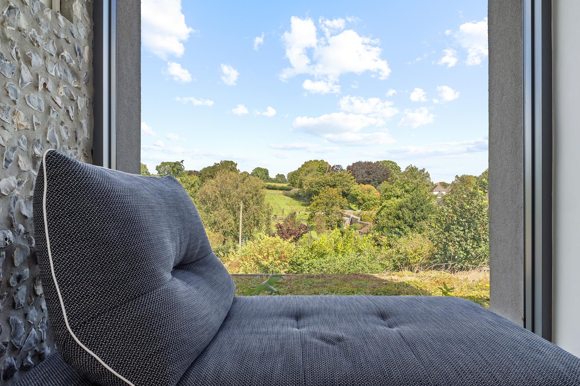 detail view of window corner and seating with internal flint wall and views over the open countryside
