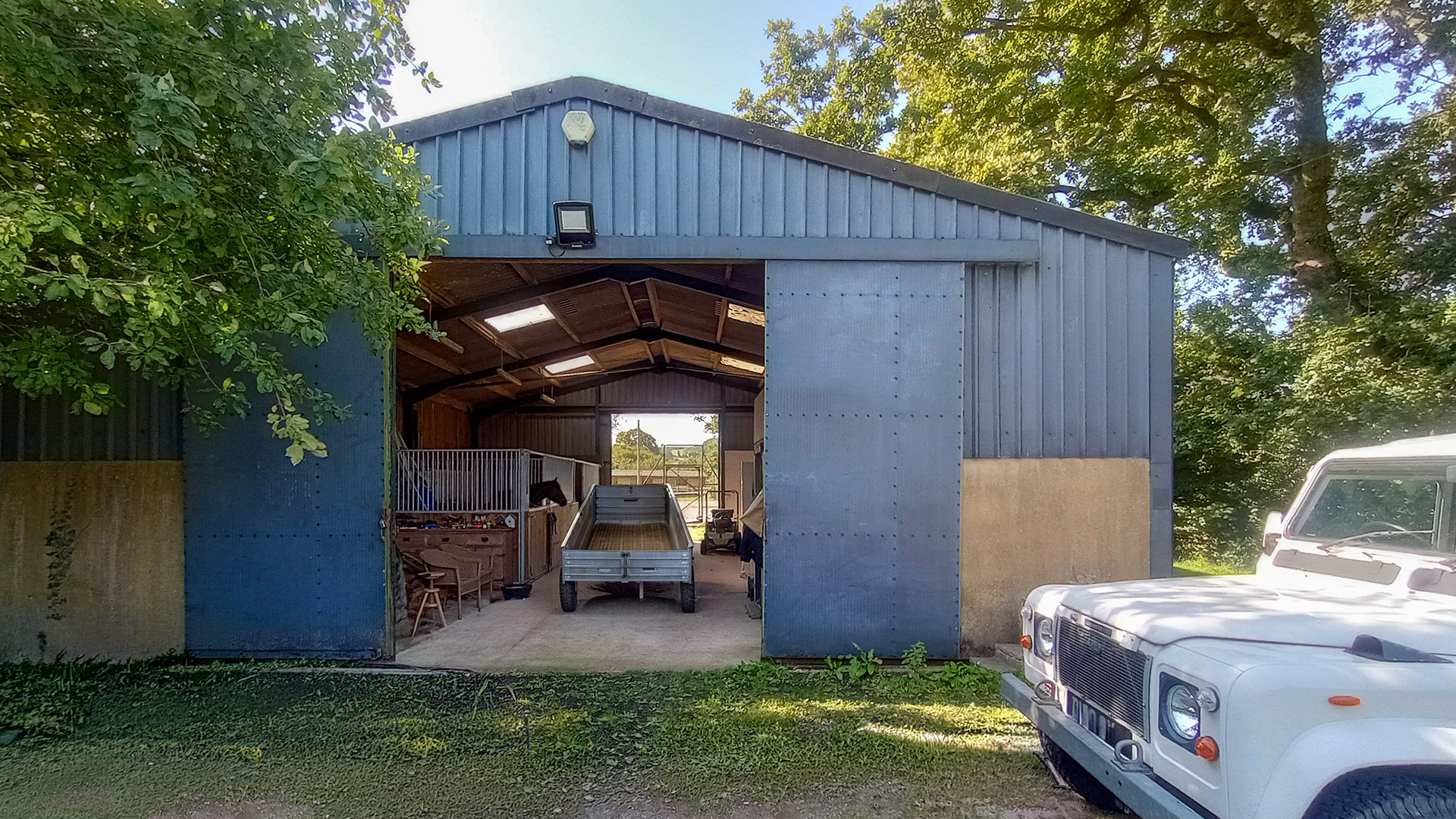 metal American indoor stables with a trailer inside