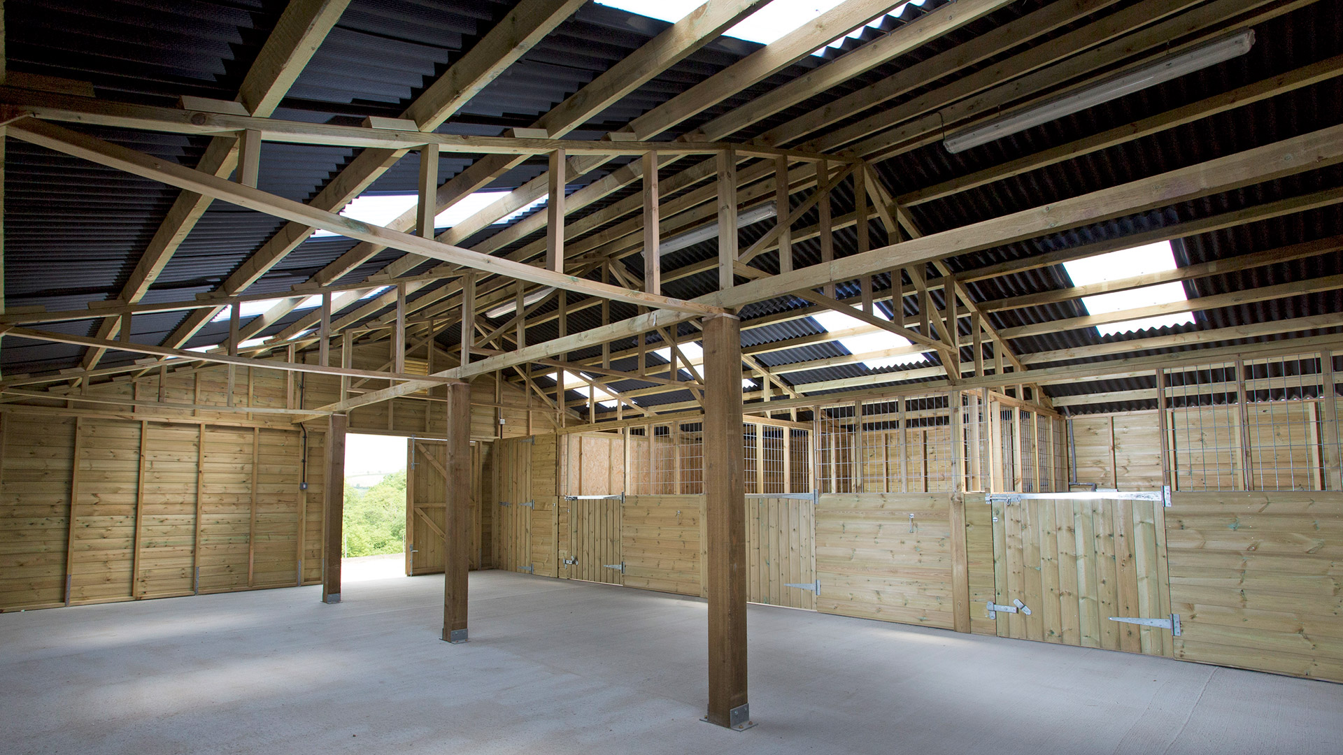 New equestrian stable barn inside with exposed timber beams