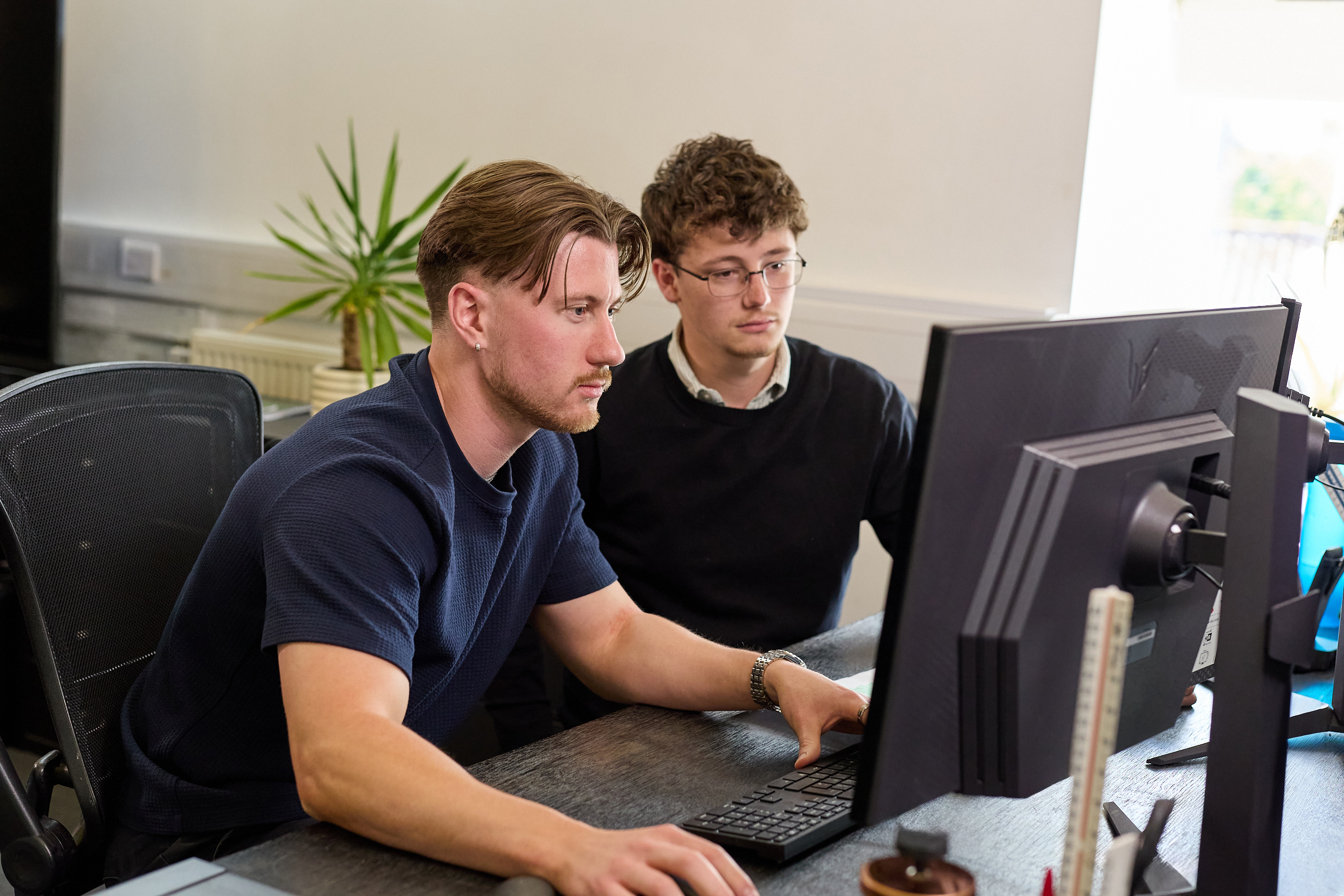 Two men looking at computer working