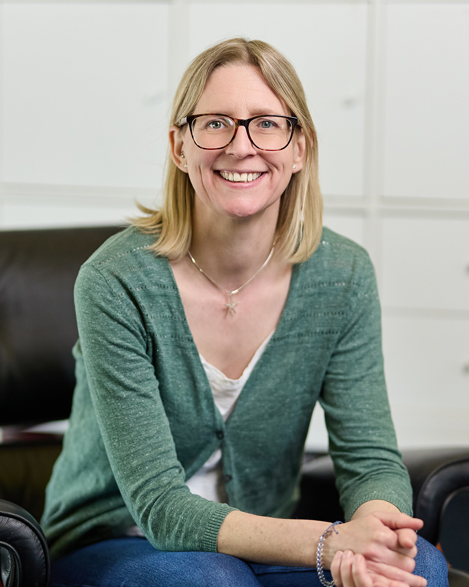 lady with glasses smiling at camera