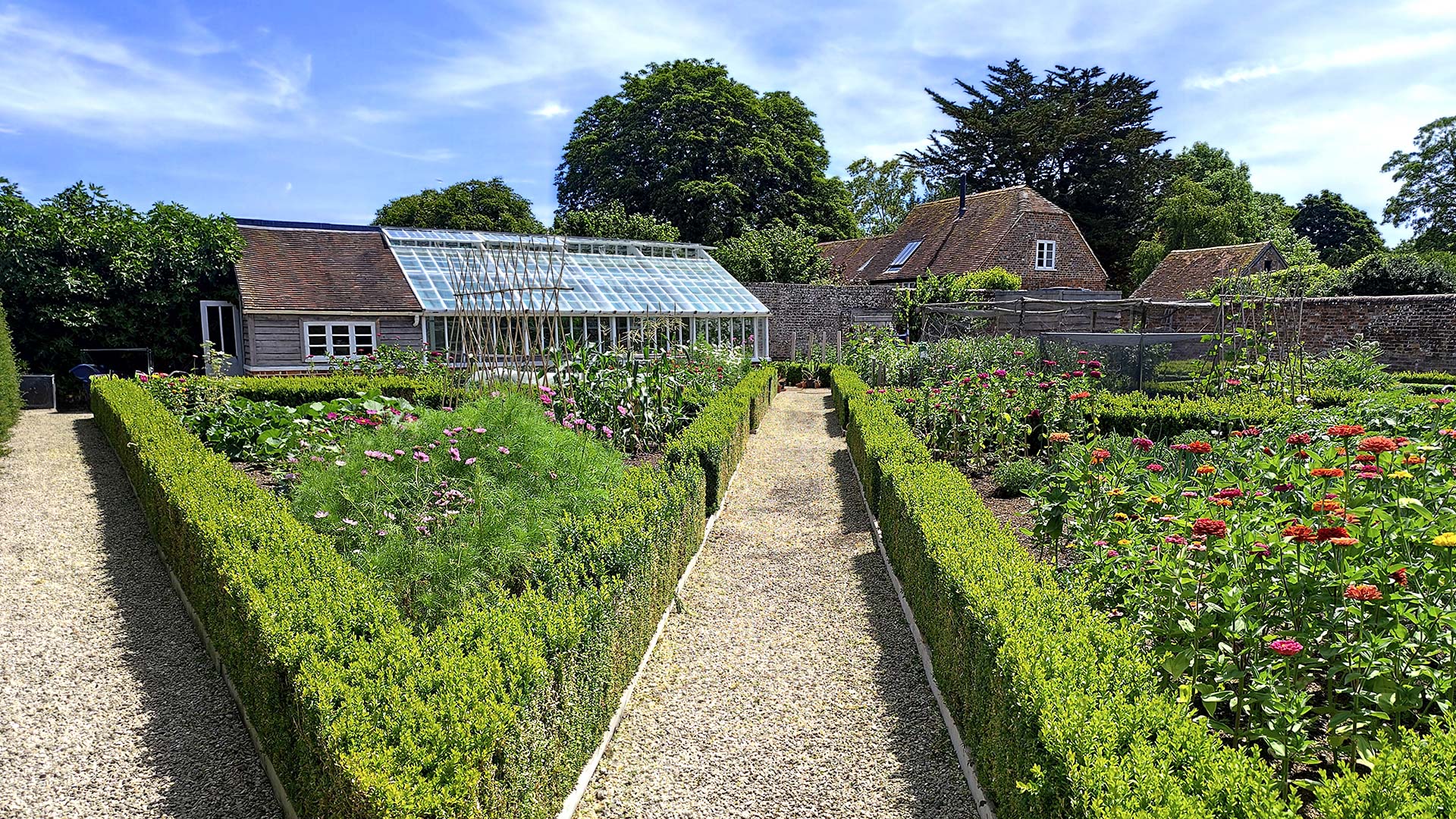 Manicure walled garden with a large greenhouse
