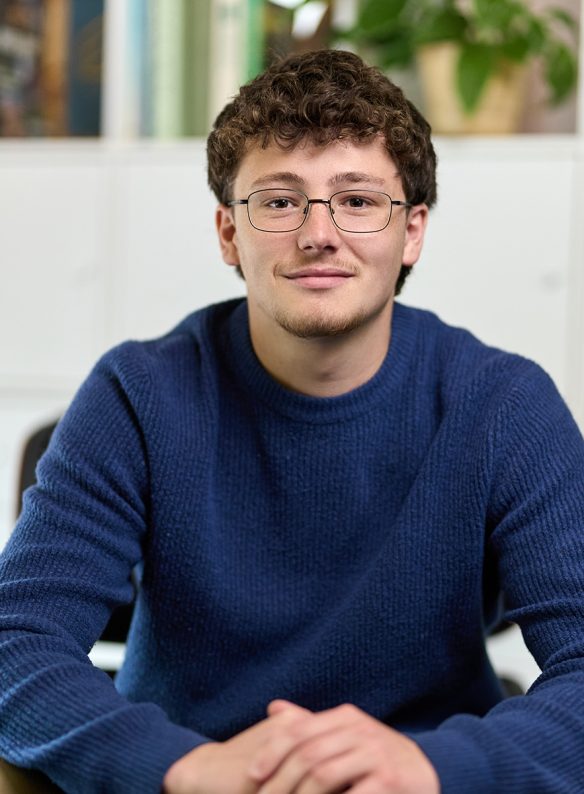 young man in jumper looking directly at camera