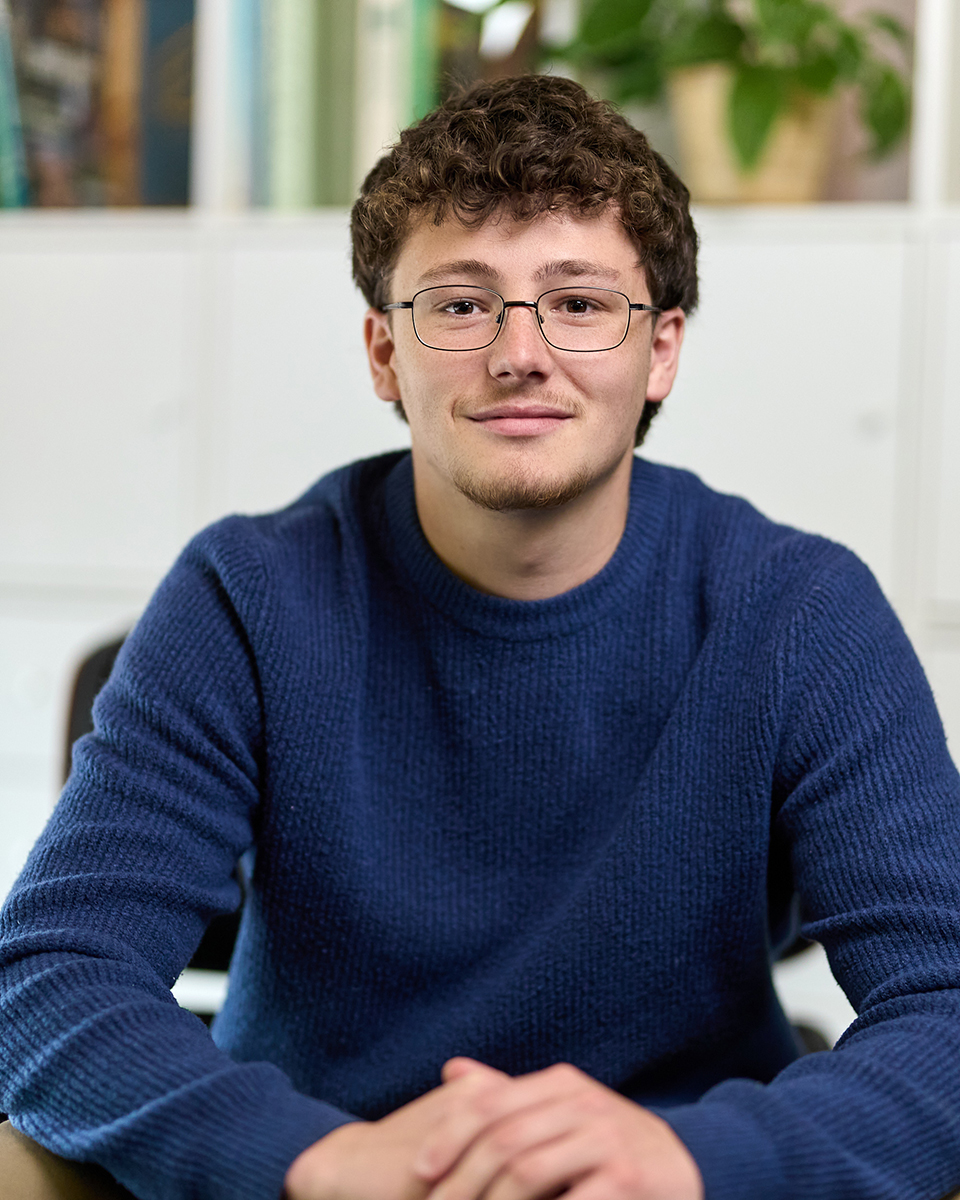 young man in jumper looking directly at camera