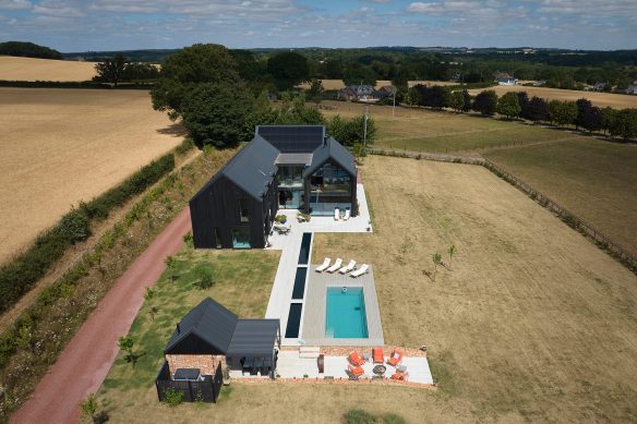 aerial view of new barn style contemporary house set in fields