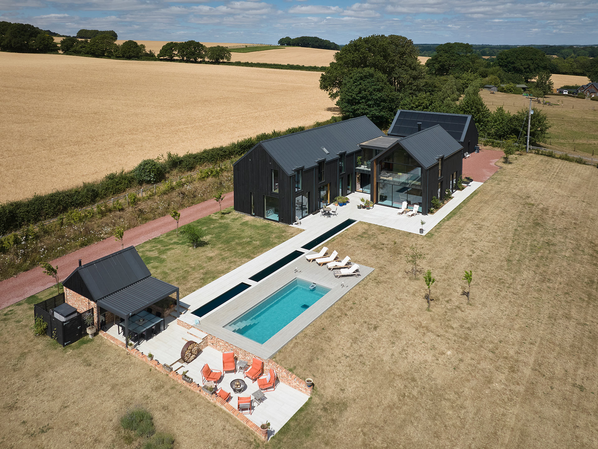 aerial view of luxury new home with swimming pool and outside kitchen