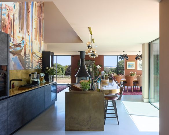 Open plan kitchen with large wall painting, glamourous kitchen island and dark coloured cupboards